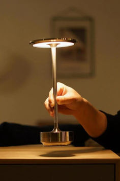 a person is holding a light on top of a table