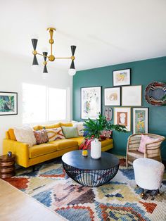 a living room filled with lots of furniture and pictures on the wall next to a coffee table