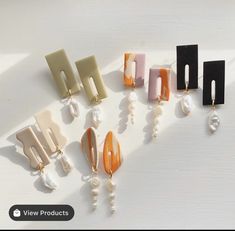 several different types of earrings on a white surface