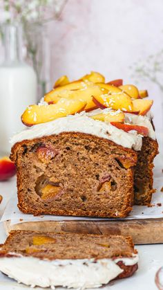 there is a loaf of fruit cake on the table next to some sliced peaches