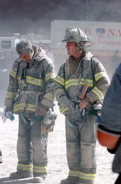 two fire fighters standing in front of a truck