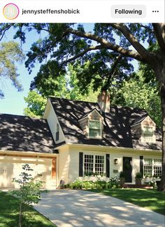 a white house with black shutters and trees