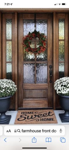 the front door is decorated for christmas with wreaths and potted flowers on it