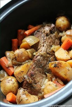 a pot roast with carrots, potatoes and meat in the crockpot is ready to be eaten