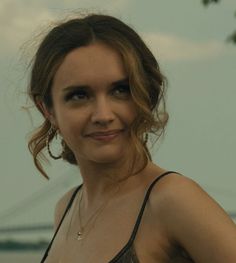 a woman is posing for the camera with her hand on her hip and wearing earrings