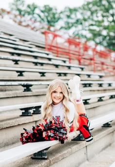 a woman sitting on the bleachers with her leg up and wearing cheerleader gear