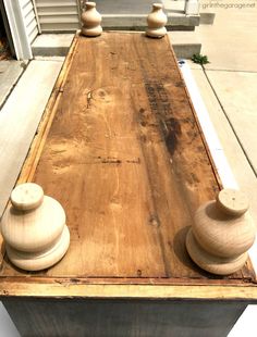 a wooden table with three vases sitting on it's top and one in the middle