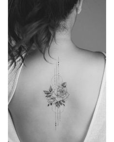 a woman's back with a rose tattoo on it