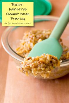 a spoon full of coconut pecan frosting sitting on top of a wooden table