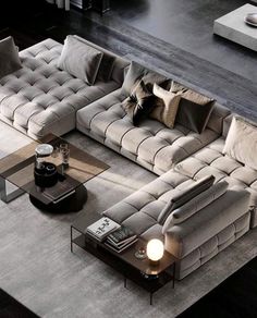 a modern living room with grey couches and pillows