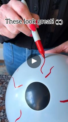 someone is painting the inside of an inflatable ball with red paint on it