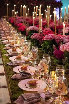 a long table is set with plates and candles