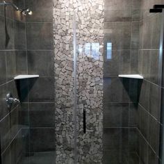 a walk in shower sitting inside of a bathroom next to a tiled wall and floor