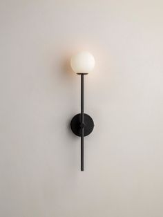 a black and white wall light mounted on the side of a wall in a room