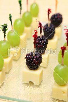 grapes and cheese are arranged on skewers with toothpicks in the form of fruit