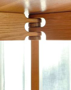 a close up of a wooden window with curtains in the background