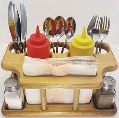 a wooden tray with utensils and spoons in it