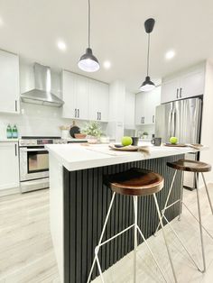 a kitchen with two stools next to an island