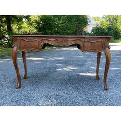 an old wooden desk sitting in the middle of a gravel road