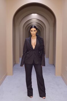 a woman in a suit is standing in the middle of a tunnel with her hands on her hips