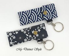 two blue and white keychains sitting next to each other