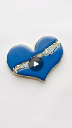 a blue heart shaped brooch with a hole in the middle and a white background