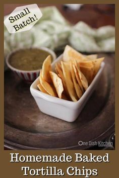 homemade baked tortilla chips on a plate with small bowl of salsa in the background