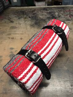 a red and white striped bag with black straps