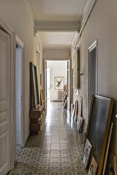 an empty hallway with paintings and pictures on the floor