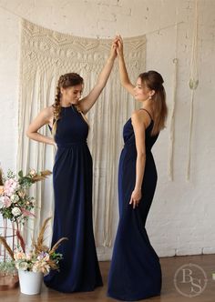 two women in long dresses standing next to each other