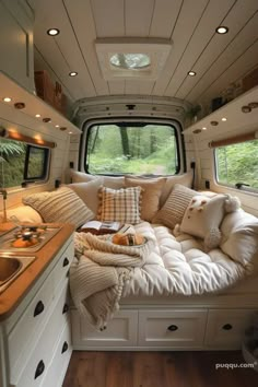 a couch in the back of a camper with pillows on it's side