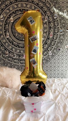 a balloon shaped like the number one sitting on top of a bed with other items