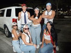 a group of people standing next to each other in front of a white van at night