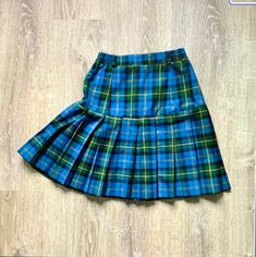 Vintage 1980s Plaid Pleated Mini Skirt Blue Green plaid drop waist pleated short above the knee skirt High waistband with elastic on sides Polyester or Polyester blend 1980s era In fabulous vintage condition I realize now that the zipper should be probably in back not in front as photos show Tag: AH CHI FASHION Size: Measures Size 4 Woman's USA--check measurements: Will fit: Waist: 25 inches and stretches to 26 inches Hip: 36 inches to 37 inches--measured 8 inches below the waist Length: 19 1/2 inches--short above the knee