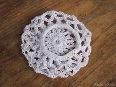 a white crocheted doily sitting on top of a wooden table