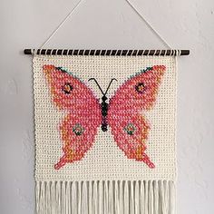 a wall hanging with a pink butterfly on it