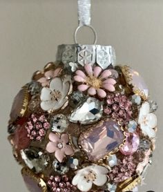 a christmas ornament with lots of flowers and jewels hanging from it's side