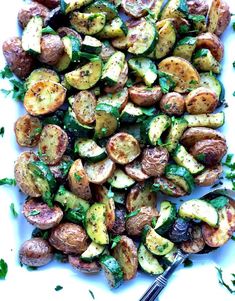 roasted potatoes and zucchini with herbs on a white plate