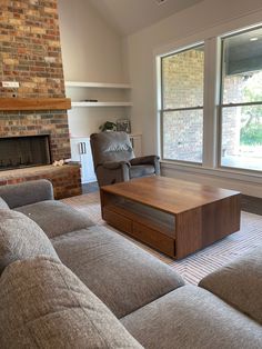 a living room filled with furniture and a fire place in front of a brick wall