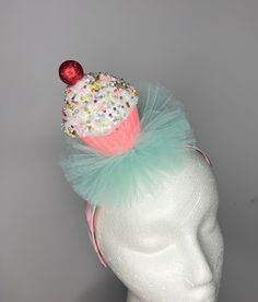 Sprinkles cupcake in pink glitter wrapper with cherry on top - blue/aqua  tulle - 1 inch wide white satin headband striped with pink ribbon  Lightweight and comfortable  One size fits most Whimsical Party Supplies For Birthday And Carnival, Whimsical Pink Headband For Party, Fun Party Hair Accessories For Carnival, Playful Multicolor Headband For Party, Novelty Adjustable Headband For Birthdays, White Novelty Party Supplies, Playful Pink Party Headband, Cute Birthday Headband Hair Accessories, Whimsical Pink Headband For Birthday