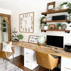 a desk with two chairs and a large clock on the wall above it in a home office