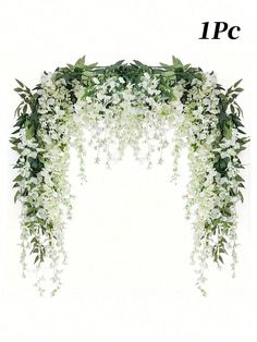 white flowers and greenery are arranged on the top of an arch with green leaves