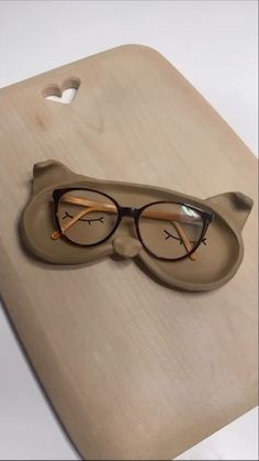 a pair of glasses sitting on top of a cutting board with eyeglasses attached to it