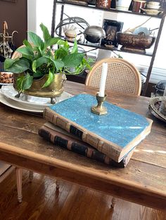 a wooden table topped with two books and a potted plant on top of it