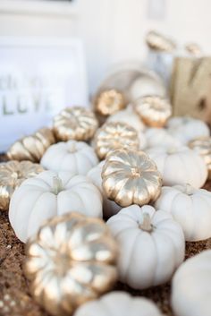 some white pumpkins are laying on the ground