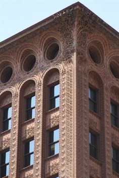 the top of a tall building with ornate designs on it's sides and windows