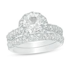 a white gold ring set with an oval cut diamond surrounded by round brilliant pave diamonds