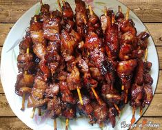 several skewered meats are on a plate with toothpicks in them