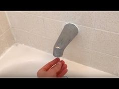 a person is using a soap dispenser to clean a bathtub