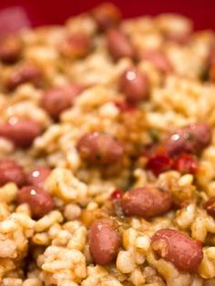 rice and beans are mixed together in a red bowl